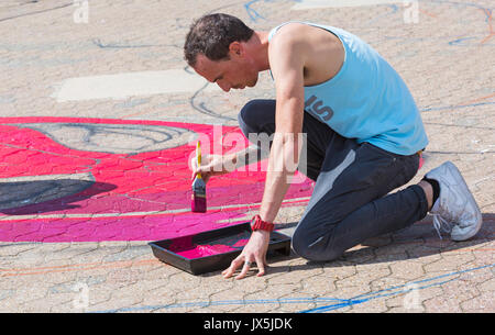 Bournemouth Dorset, Regno Unito. Il 15 agosto, 2017. Grandi opere di Spiderman sta prendendo forma sul molo approccio, disposti da Ambassadeur Art. Artista maschile, uomo, verniciatura con vernice rossa con lo strumento pennello e vernice vassoio. Credito: Carolyn Jenkins/Alamy Live News Foto Stock