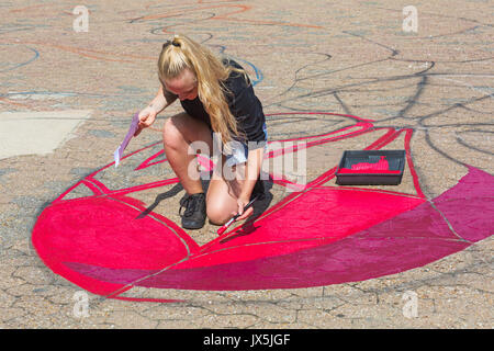 Bournemouth Dorset, Regno Unito. Il 15 agosto, 2017. Grandi opere di Spiderman sta prendendo forma sul molo approccio, disposti da Ambassadeur Art. Giovane donna Uomo Ragno di verniciatura con vernice rossa con spazzola di vernice e il vassoio. Credito: Carolyn Jenkins/Alamy Live News Foto Stock