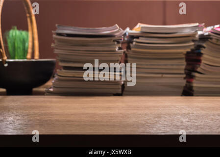 Messa a fuoco su un tavolo di legno con libri e riviste disposizione dello stack sfondo sfocato Foto Stock