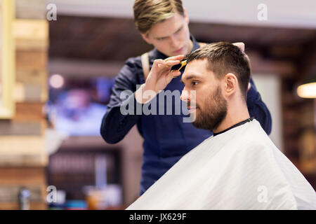 L uomo e il barbiere il taglio di capelli al barbiere Foto Stock