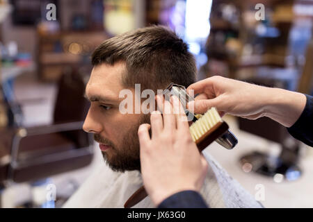 L uomo e il barbiere mani con rifinitore per peli di taglio Foto Stock