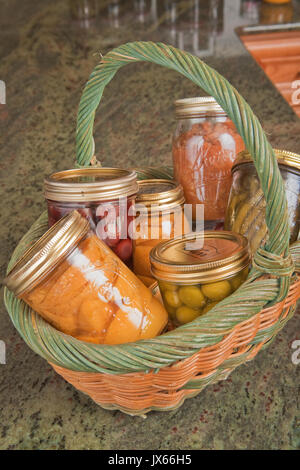 Cesto in Vimini di casa conserve alimentari (pesche, olive, fagioli verdi e le ciliegie) in cucina in Issaquah, WA Foto Stock