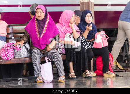 Le donne musulmane seduto su una panchina di piattaforma in attesa di un treno, Hua Lamphong stazione ferroviaria, Bangkok, Thailandia Foto Stock