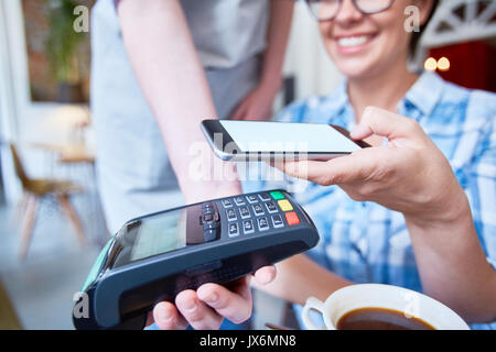 Il pagamento per il caffè con lo smartphone Foto Stock