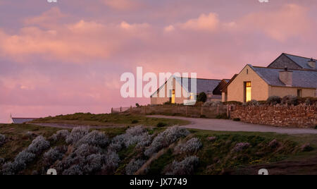 Vista al tramonto di due bungalow di fronte al mare a Newquay, Cornwall, Regno Unito Foto Stock