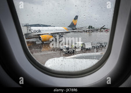 Vista da una finestra di aereo sulla pista dell'aeroporto di Manchester sotto la pioggia. Foto Stock