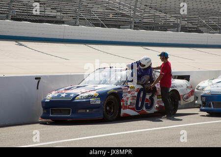 Dover, Delaware - agosto 13,2017 : NASCAR driver di automobile di entrare attraverso la finestra con pit crew sulla fila di pit a Dover Motor Speedway con supporti vuoti. Foto Stock