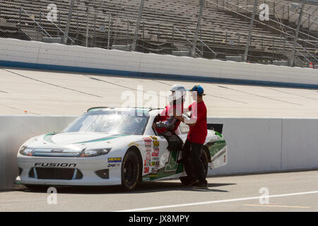 Dover, Delaware - agosto 13,2017 : NASCAR driver di automobile di entrare attraverso la finestra con pit crew sulla fila di pit a Dover Motor Speedway con supporti vuoti. Foto Stock