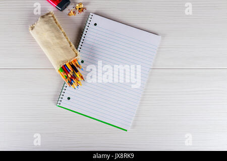 Vuoto il blocco note e penna a colori su legno Notebook blackground matite colorate Foto Stock