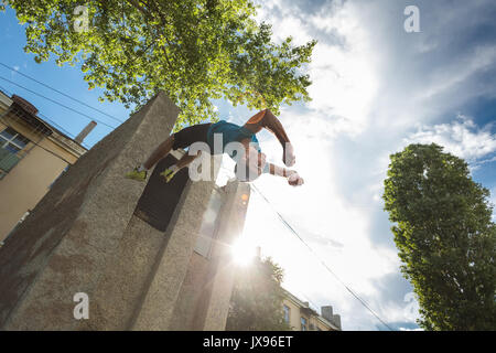 Città parkour. Il ragazzo non il contrario somersault. Le riprese dall'angolo inferiore. La destrezza ed estreme. Foto Stock