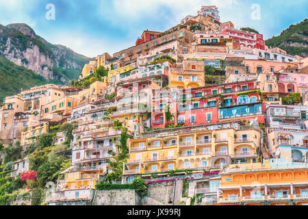 Vibranti colori pastello di cliffside case e giardini sul lungomare a Positano, Italia. Vista dal mare. Foto Stock
