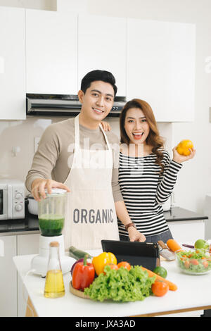 Felice coppia asiatica in amore in cucina rendendo succo sano Foto Stock