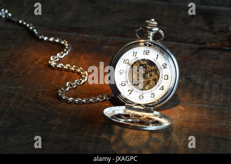 Vintage orologio da tasca con coperchio aperto e la catena su una superficie di legno Foto Stock