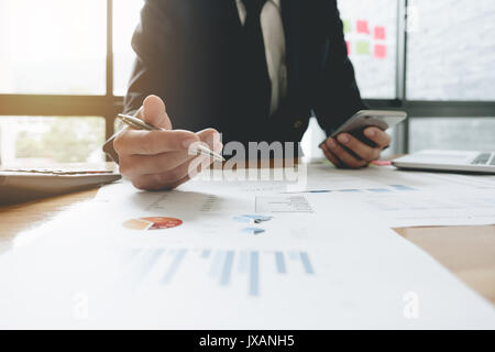 Uomo d'affari consulente per gli investimenti della società di analisi la relazione finanziaria annuale bilancio dichiarazione di lavoro con documenti grafici. Concetto di immagine Foto Stock