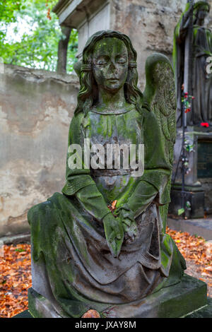 Antica statua di pietra della bambina sul famoso vecchio cimitero Olsanske a Praga, Repubblica Ceca. Foto Stock