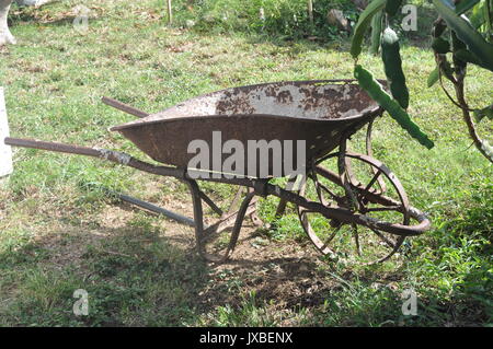 Vecchia carriola arrugginita Foto Stock