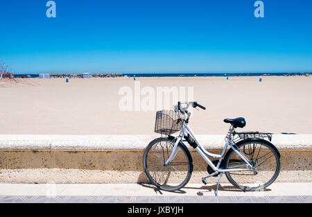 Una bicicletta parcheggiata nel lungomare del popolare La spiaggia di Malvarrosa, a Valencia, Spagna Foto Stock