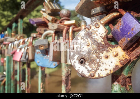 Vecchio arrugginito lucchetti sul ponte di un amore, simbolo, profondità di campo. Foto Stock