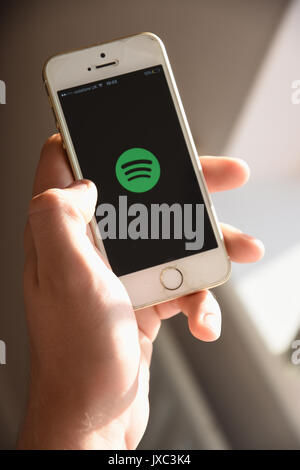 Bianco Apple se il telefono cellulare che mostra il logo Spotify sul suo schermo Foto Stock