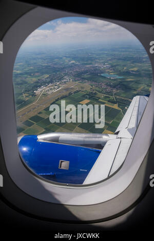 Guardando verso il basso sul verde patchwork campi attraverso un aereo oblò finestra poco dopo il decollo dall'aeroporto di Monaco di Baviera, Germania Foto Stock