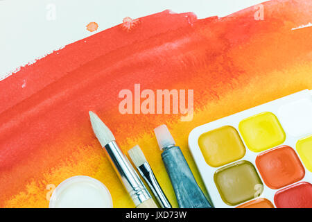 Abstract acquerello rosso texture con tavolozza di colori e vari pennelli Foto Stock