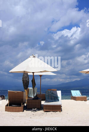 Gili Trawangan spiagge di sabbia bianca e blu cielo - ombrellone e lettini sulla calda sabbia bianca Foto Stock