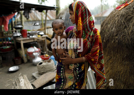 Bogra, Bangladesh. 16 Ago, 2017. Donna con il suo bambino rifugiarsi in un luogo aperto per le inondazioni in area Kajla a Bogra. Popoli' sofferenza continua come molti di loro hanno lasciato le loro case con i loro capi di bestiame, capre, galline e altri animali domestici e ha trovato rifugio in zone sicure, e molte di queste persone non sono ancora stati in grado di tornare come acqua non è completamente ritirato dalle loro case. Flood-incidenti correlati a Dinajpur, Gaibandha Lalmonirhat e aumentando il numero di morti per 30 negli ultimi tre giorni in tutto il paese. Credito: K M Asad/ZUMA filo/Alamy Live News Foto Stock