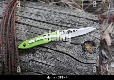 Piccolo Coltello chiudibile con un apribottiglie. Moncone grigio. Foto Stock