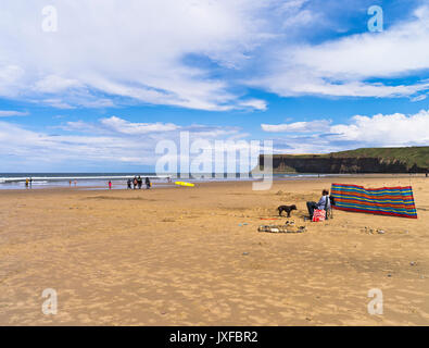 dh Yorkshire spiaggia SALTBURN PRESSO IL MARE CLEVELAND Man sedia a sdraio Cane windbreaker costa linea uk mare sabbia gente Inghilterra estate Foto Stock