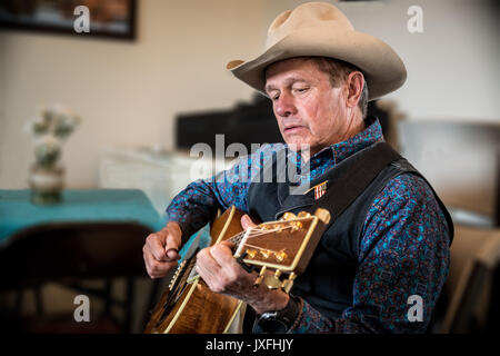 Western cowboy a suonare la chitarra Foto Stock