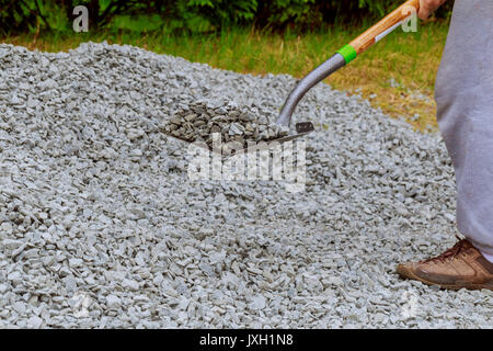 La pala di gettare le pietre in gabione scagliare pietre con una pala Foto Stock
