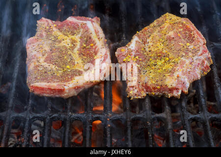 Un top bistecca di controfiletto arrostito alla fiamma su un barbecue, una profondità di campo ridotta. Foto Stock