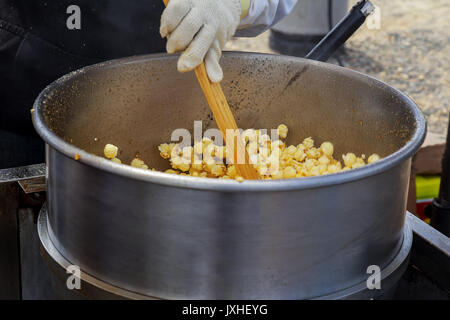 Fare popcorn nel piccolo chiosco. Calore, burro e sale sono gli ingredienti chiave per deliziosi. Foto Stock