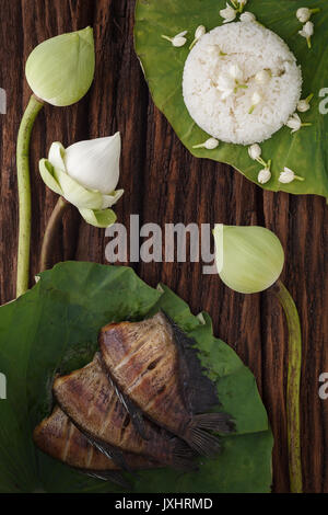 Cibo tailandese riso e secche, salate fanciulla il pesce fritto con fiore di lotus jasmine decorazione su sfondo in legno bellissimo appartamento lay ancora vita rustica asia Foto Stock