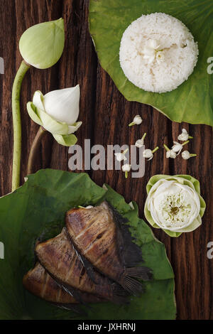 Cibo tailandese riso e secche, salate fanciulla il pesce fritto con fiore di lotus jasmine decorazione su sfondo in legno bellissimo appartamento lay ancora vita rustica asia Foto Stock