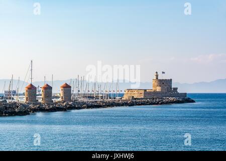 Agios Nikolaos Fort (Forte di San Nicola) e mulini, all'entrata di Mandraki Harbour, l' isola di Rodi, Grecia Foto Stock