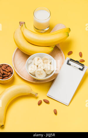 Banana e latte sulla carta gialla con sfondo bianco appunti per il testo Foto Stock