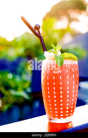 La pina colada giallo stile freschi cocktail drink di frutta con ananas in un bicchiere alto al tramonto in un resort Isola di Phuket, Tailandia Foto Stock