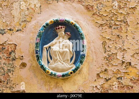 Una ceramica Madonna dei religiosi di decorazione su un vecchio muro con peeling vernice in Mdina Malta Foto Stock