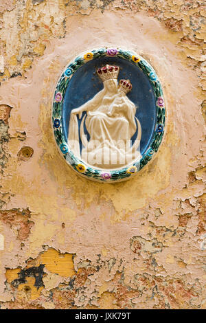 Una ceramica Madonna dei religiosi di decorazione su un vecchio muro con peeling vernice in Mdina Malta Foto Stock