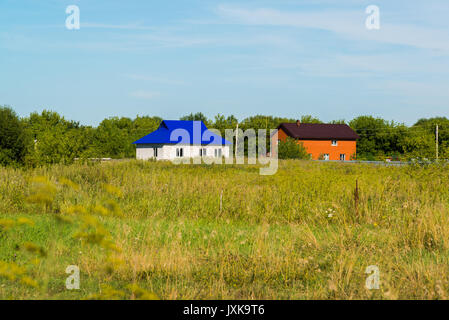 Case fatte di bianco e mattoni rossi nel villaggio Foto Stock