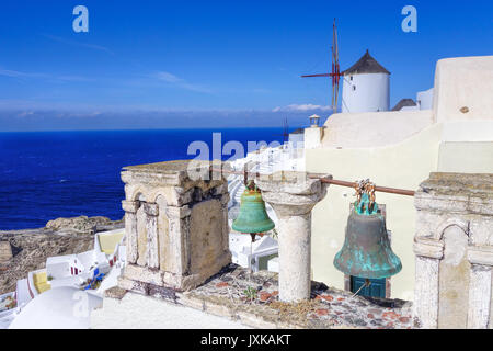 Mulino a vento con le campane della chiesa a Santorini, Grecia Foto Stock