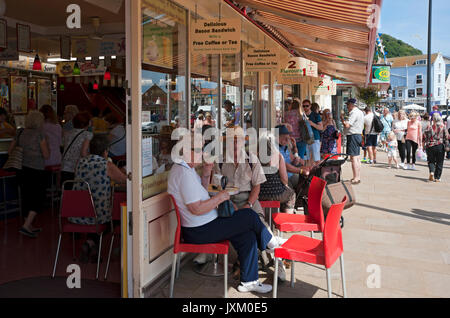 Persone visitatori turisti seduti all'esterno dell'Harbour Bar caffetteria negozio in estate Scarborough North Yorkshire Inghilterra Regno Unito Gran Bretagna Foto Stock