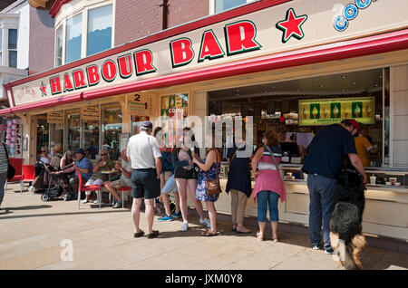 Le persone visitano i turisti fuori dall'Harbour Bar Cafe, negozio in estate, sul lungomare di Scarborough, North Yorkshire, Inghilterra, Regno Unito, Gran Bretagna Foto Stock