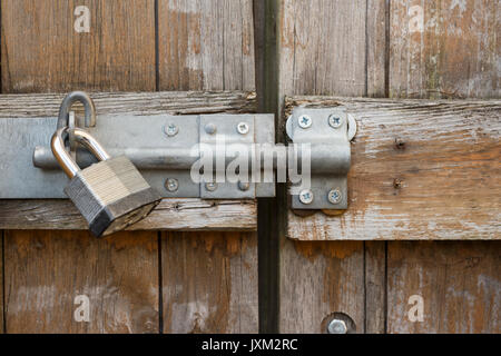 Per impieghi pesanti serratura e lucchetto sul cancello di legno. Foto Stock