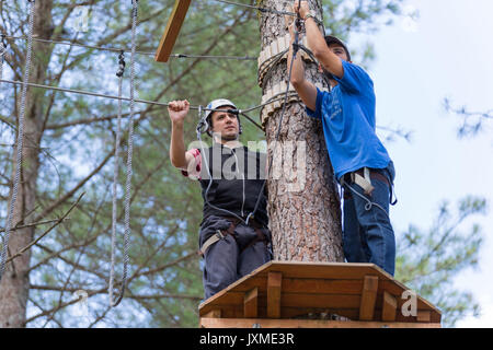 MEZIO, Portogallo - 22 luglio 2017: uomo avventuroso si prepara a una diapositiva in zip fodera attraverso la foresta. Luglio 22, 2017, Mezio, Portogallo. Foto Stock