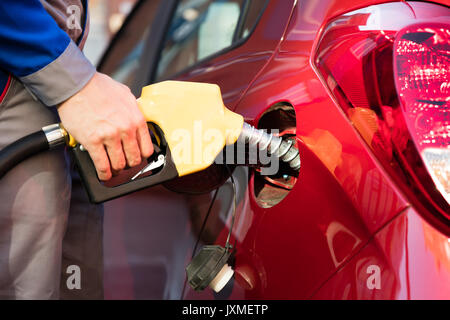 Persona della mano il rifornimento auto del serbatoio di contenimento della pompa benzina ugello Foto Stock