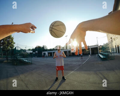 Punto di vista immagine di uomo gettando basketball presso il compagno di squadra Foto Stock