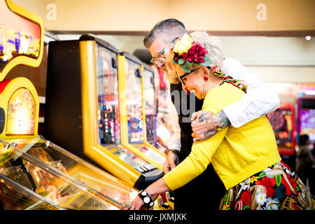 Giovane divertirsi nella sala giochi, Bournemouth, Inghilterra Foto Stock