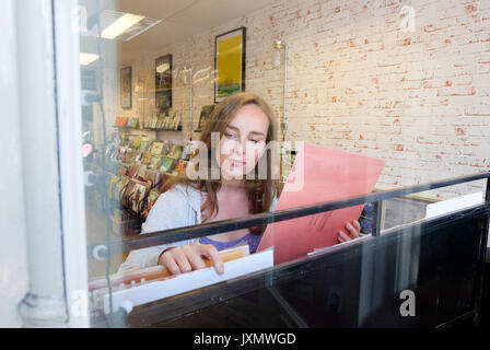 Giovane donna guardando a dischi in vinile in archivio di record Foto Stock